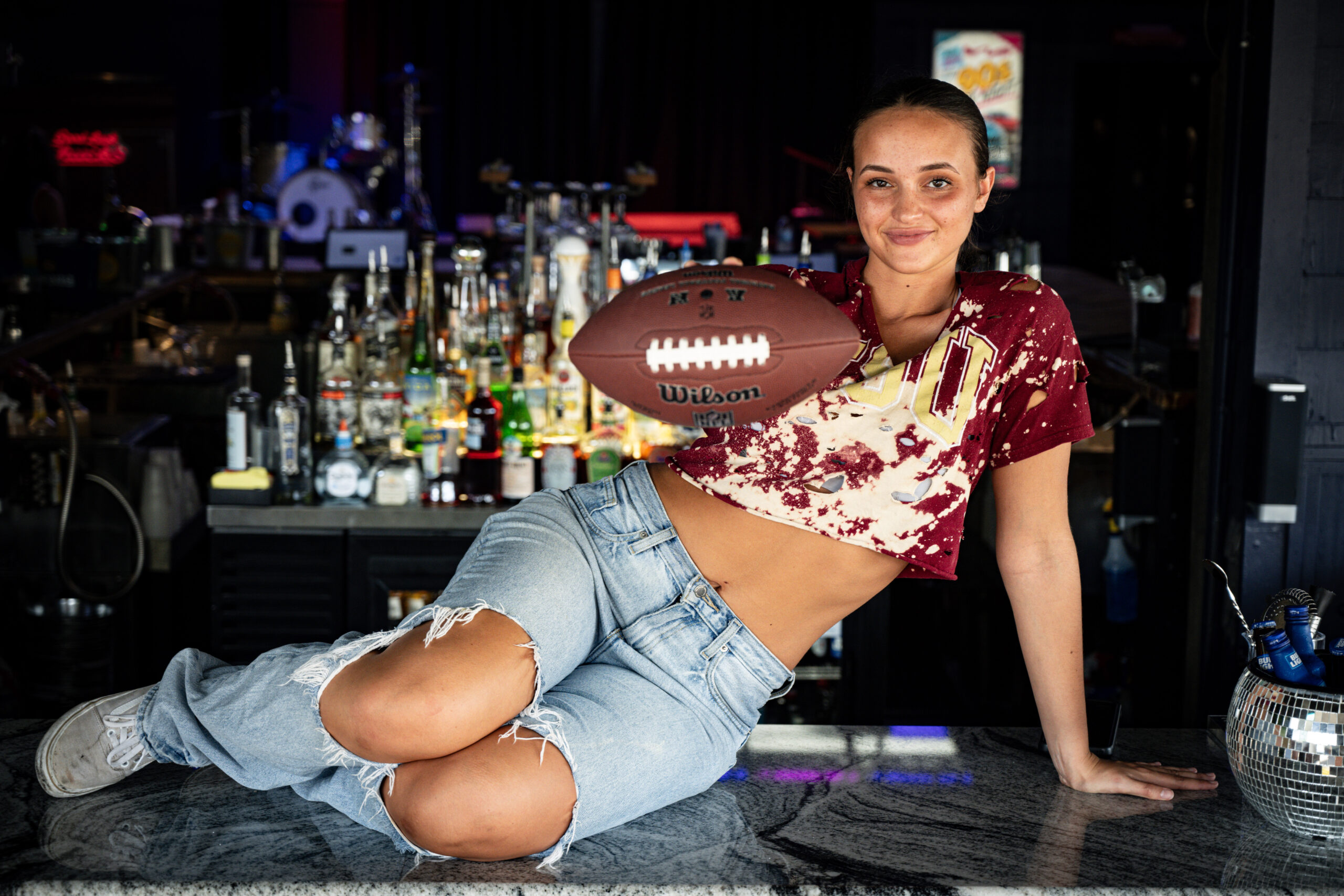 girl in a seominole shirt holding a football